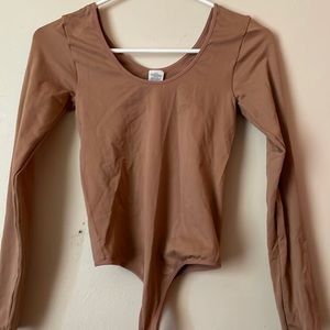 This is a pinkish/tan thong bodysuit extra small with a scoop neck